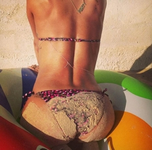 Riri en bikini avec un timbre de sable aux fesses